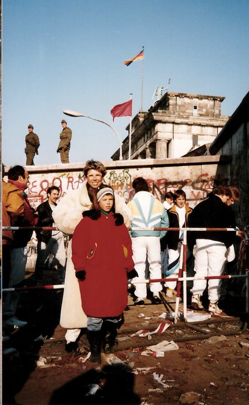 Annika Hinze with her mother in front of the Berlin Wall  by the Brandenburg gate as East German soldiers stand guard. Courtesy of Annike Hinze