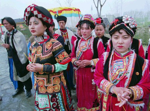 Members of some of Chinas many ethnic minorities prepare for a ceremony to mark the Dai minoritys Water Sprinkling Festival at Beijings Ethnic Culture Park Saturday April 13, 1996. The festival involves people sprinkling water on each other to express goodwill. (AP Photo/Greg Baker)