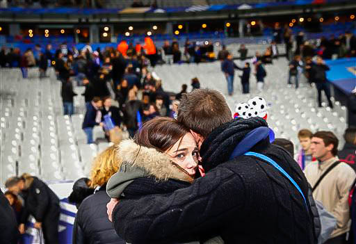 Spectators embrace each other as they stand on the playing field of the Stade de France stadium at the end of a friendly soccer match between France and Germany in Saint Denis, outside Paris, Friday, Nov. 13, 2015. Hundreds made their way to the pitch after explosions were heard nearby. Multiple fatal attacks throughout the city have prompted President Francois Hollande to announce he was closing the countrys borders and declaring a state of emergency. (AP Photo/Christophe Ena)