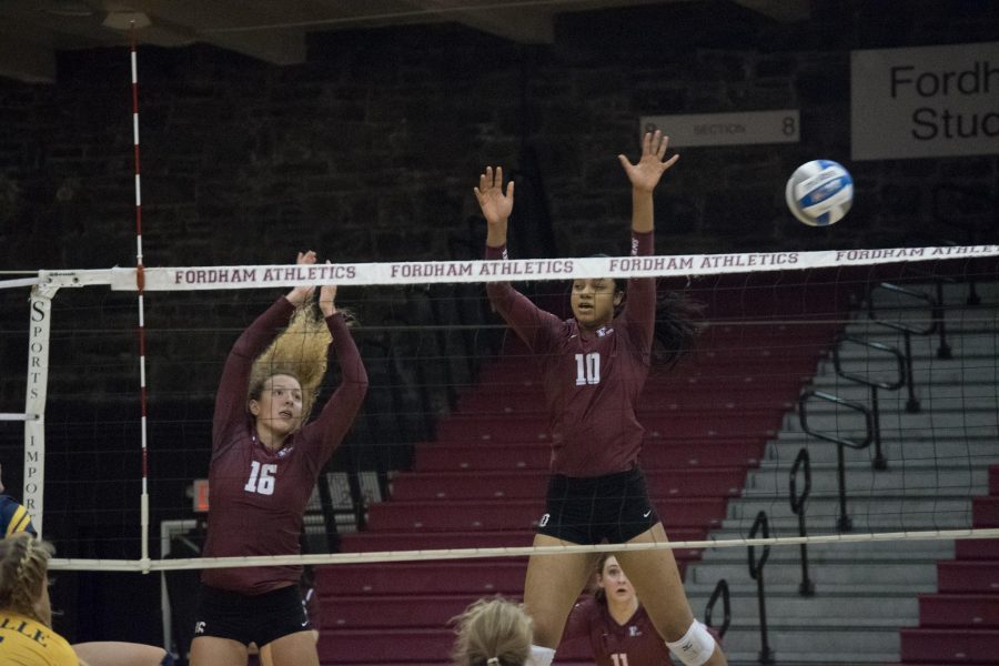 Olivia Fairchild (L, 16) and Elise Benjamin (R, 10) go up for a block. (Andrea Garcia/The Fordham Ram)