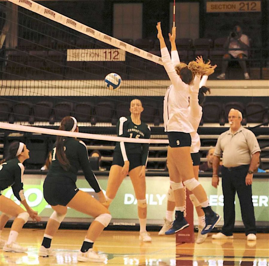 Freshman middle blocker Claire O’Neal (9) sends a ball back over the net. (Julia Comerford/The Fordham Ram)