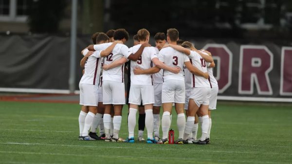 The 2023 men’s soccer team huddles together on their home field to discuss game play. (Courtesy of Fordham Athletics)