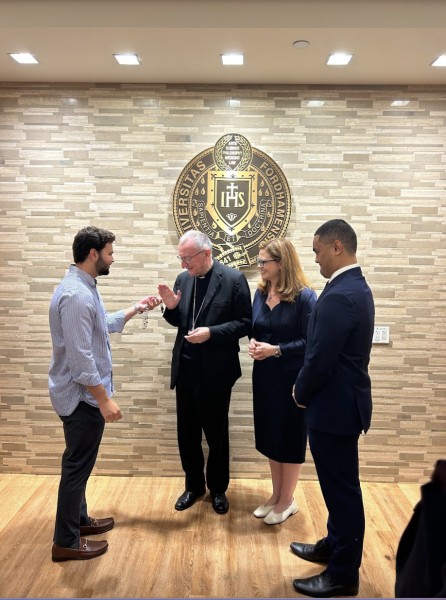 Cardinal Parolin blesses a student's rosary at the post-Mass reception in Bepler Commons. (Courtesy of Allison Schneider/The Fordham Ram)