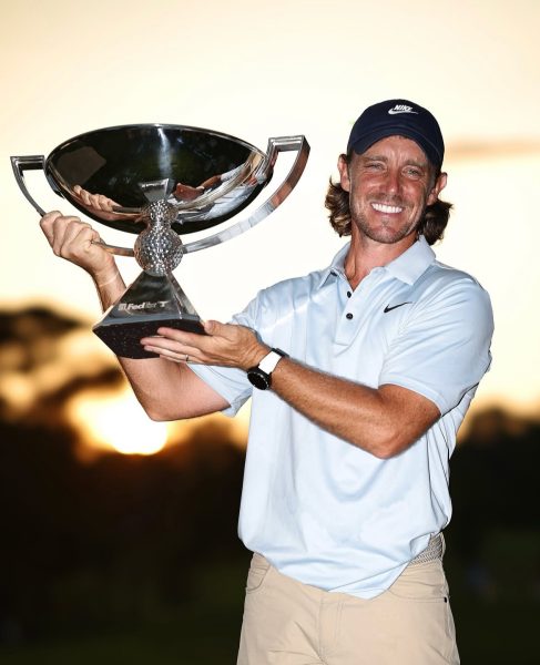 Professional golfer Tommy Fleetwood hoists the PGA Tour Championship trophy.