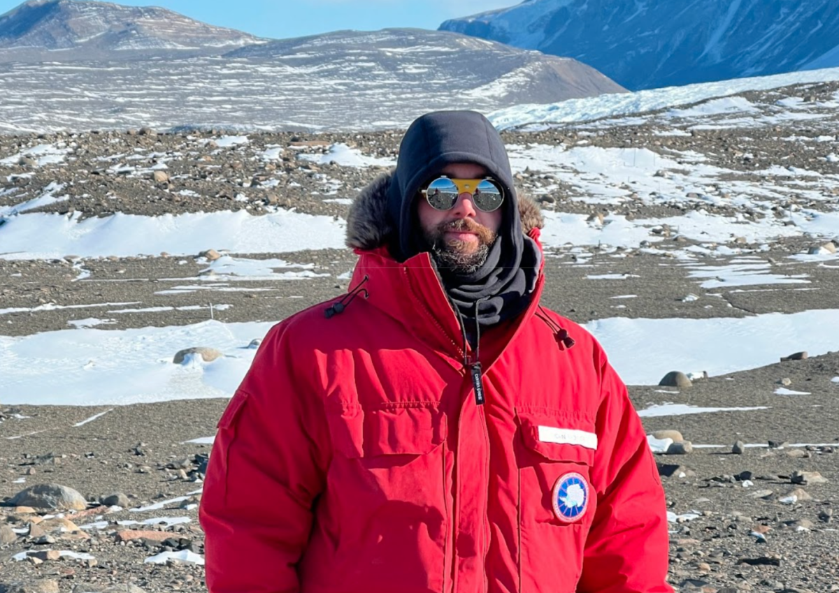 John Fromer stands in front of an Antarctic mountain wearing winter gear. (Courtesy of John Fromer for The Fordham Ram)