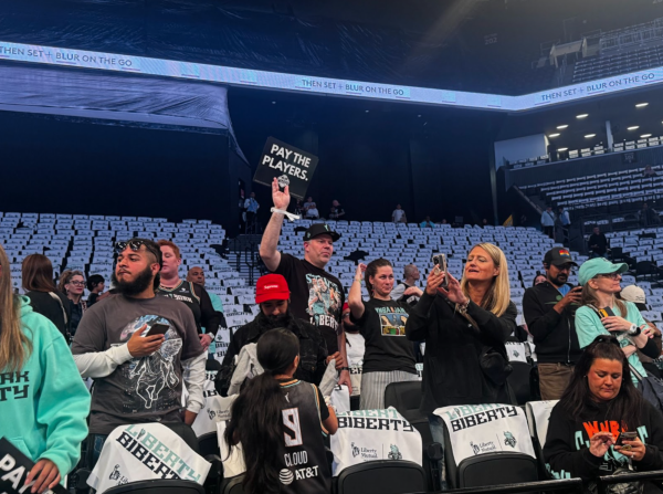 A man holds up a “PAY THE PLAYERS” protest sign at game two of the first round of WNBA Playoffs.