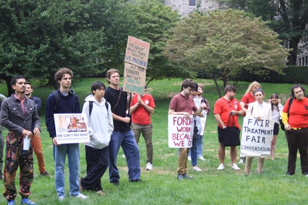 Over 50 graduate students, many holding signs, gathered in front of the William D. Walsh Family Library. (Sienna Reinders/ The Fordham Ram) 