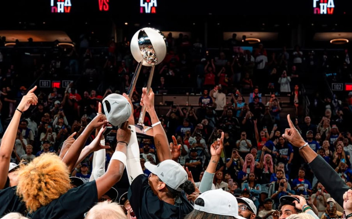 Members of the Las Vegas Aces hoist the WNBA championship trophy.