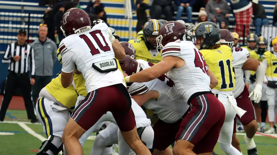 A group of Fordham defenders tackle the Merrimack ballcarrier.