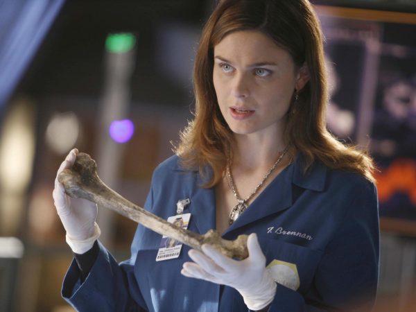 Emily Deschanel as Dr. Temperance Brennan examining a bone in the popular crime show "Bones."